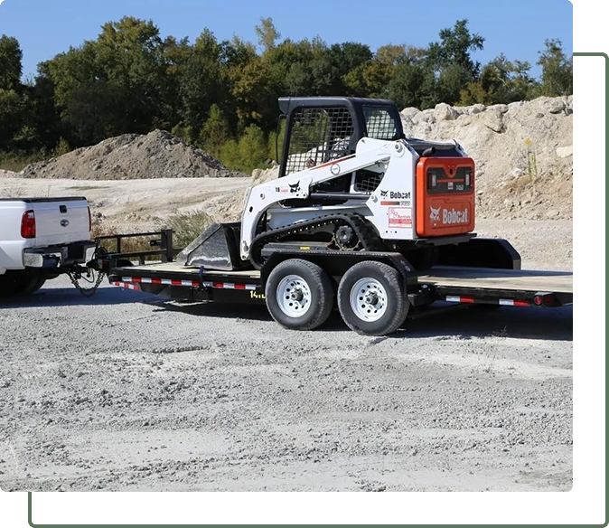 A white and black tractor pulling a trailer